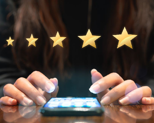 Woman filling out 5 star gold customer service feedback survey on electronic mobile device after online shopping experience - Business satisfaction ratings, retention and quality of service concepts